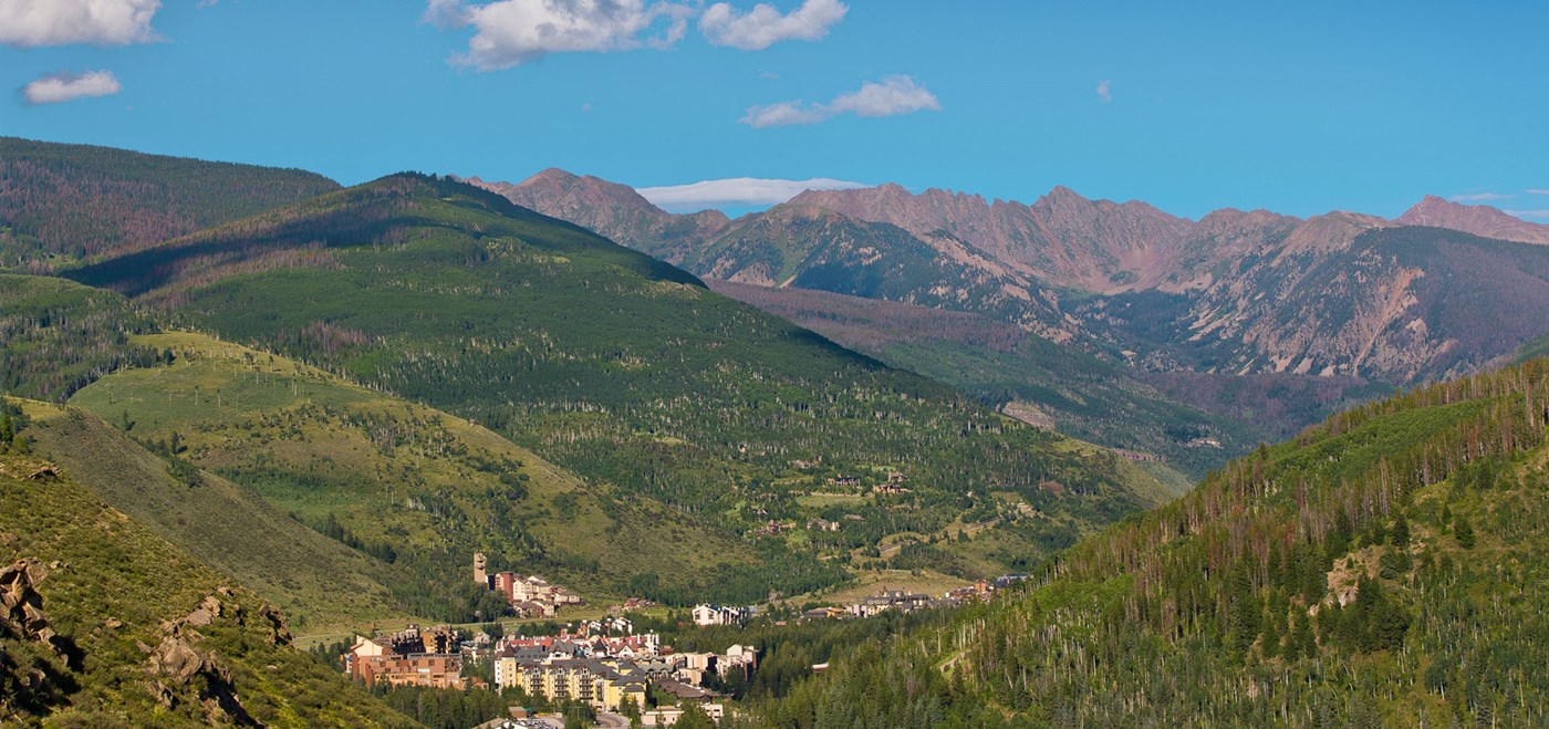 Vista of Vail village tucked in a valley surrounded by mountains 