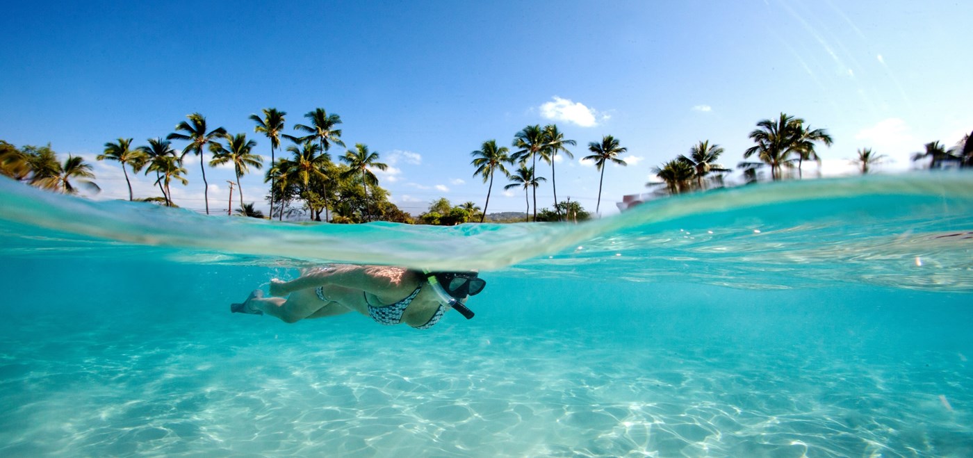 Women snorkeling through crystal clear water