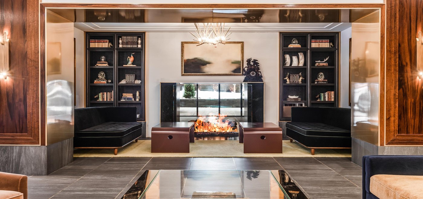 Goldener Hirsch lobby area with fireplace with black leather furniture and mirror coffee tables