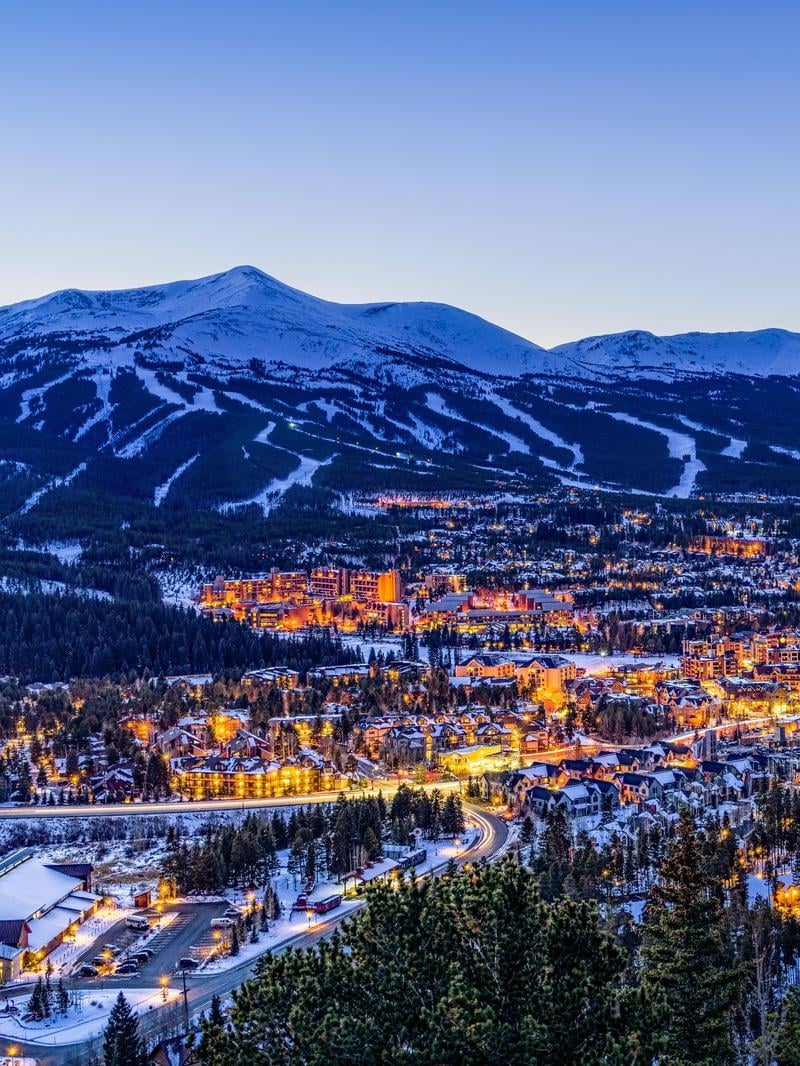 The town of Breckenridge illuminated at night with the mountain resort in the background